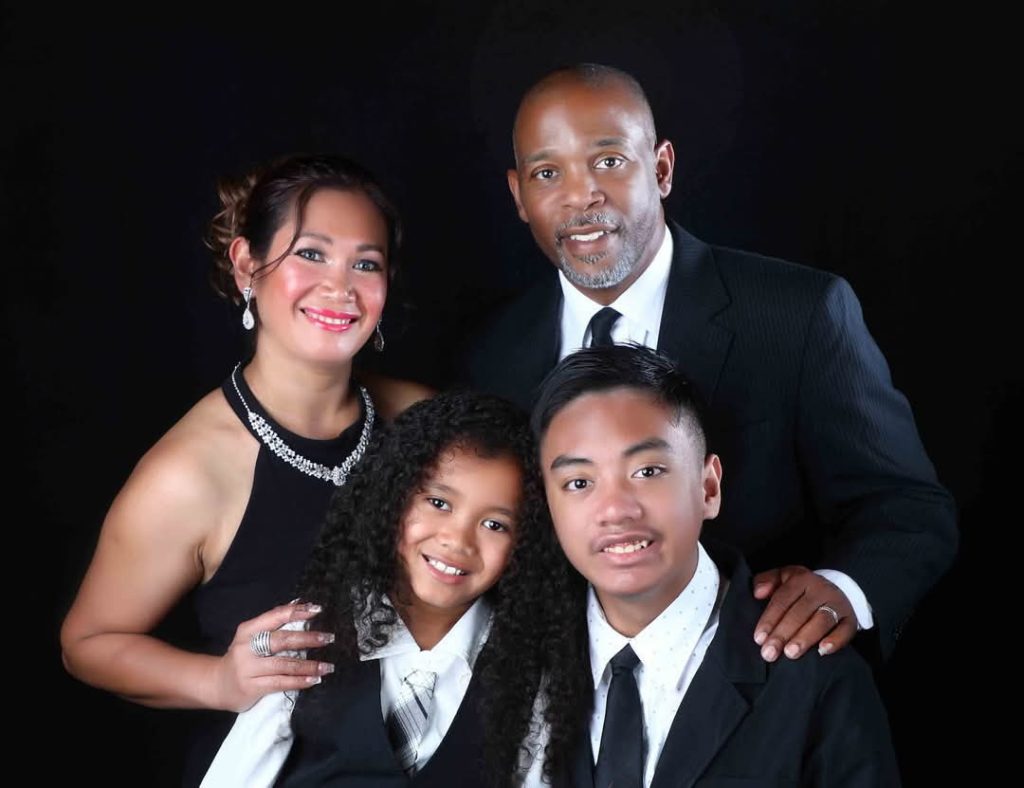 family of four, two adults, one two students, dressed formally